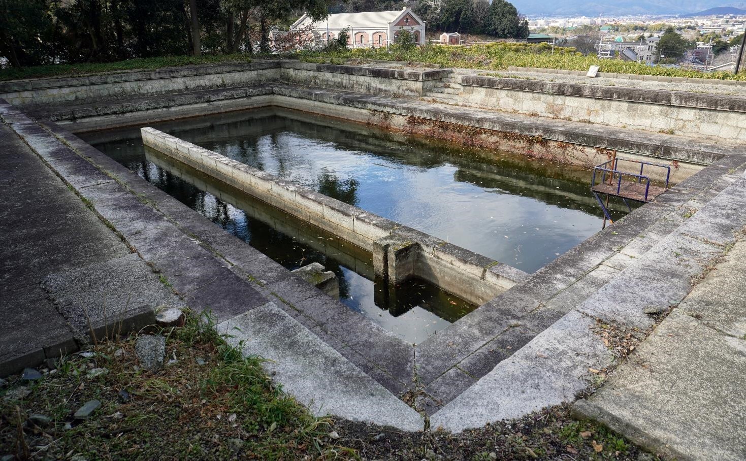 【㉔本願寺水道水源池】
<br>江戸時代に4度にわたり火事で焼失した東本願寺では、明治期の伽藍の再建に際して、防火用水の設置を計画した。明治30年、蹴上で琵琶湖疏水から取水し、市街地を地下配管で送水する本願寺水道が建設され、境内には琵琶湖疏水の水を利用した貯水槽や防火設備が設けられた。水源池は、琵琶湖疏水から取水した水を貯水する施設で、自然石を用いてつくられている。
<br>※撮影：文化庁
